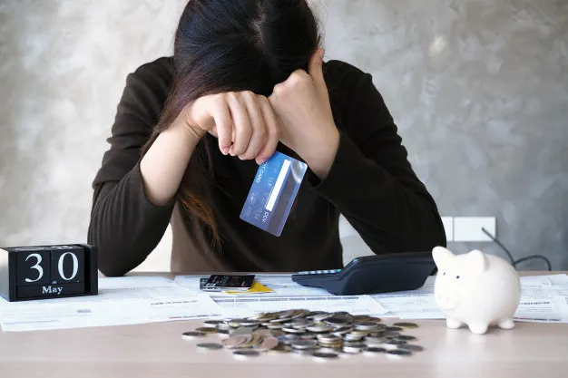 mujer-joven-deuda-tarjeta-credito-muchos-billetes-colocados-sobre-mesa